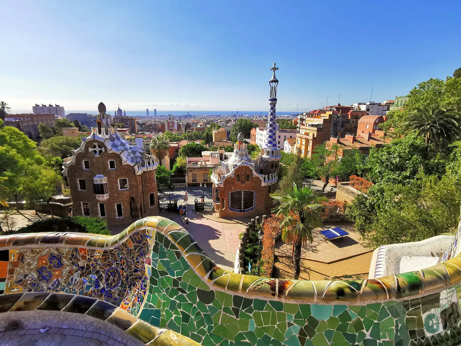 View over Park Güell's mosaic terraces toward the Barcelona skyline